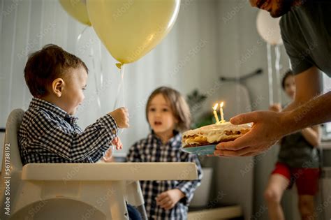 Father holding cake and celebrating son's birthday at home Stock Photo ...