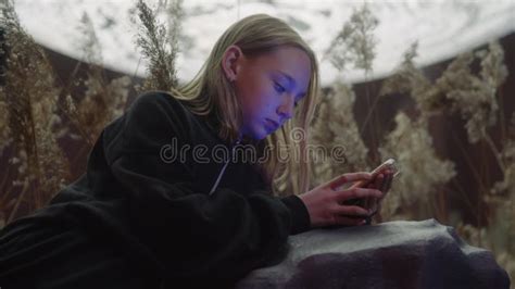 Teenage Girl Scrolling On Smartphone While Sitting By Rock At Park Stock Video Video Of