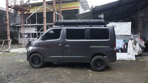 A Grey Van Parked In Front Of A Building With Scaffolding On The Side