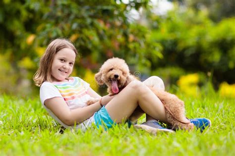 Los Niños Juegan Con Cachorro Niños Y Perros En El Jardín Imagen de