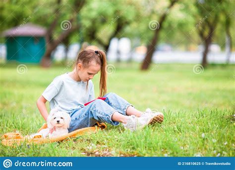 Petite Fille Souriante Jouant Et Serrant Chiot Dans Le Parc Image Stock