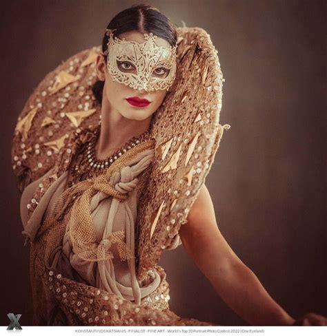 A Woman Wearing A Masquerade With Wings On Her Head