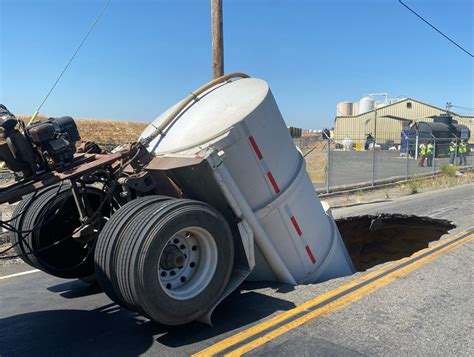 Shocking Images Show Truck Swallowed By Sinkhole As Road Collapses