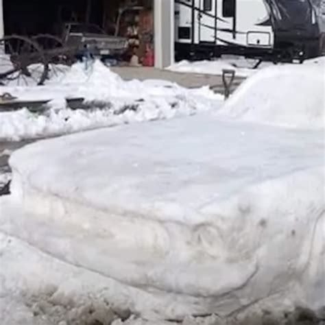 Officer stops to give “ticket” to what appears to be a snow-covered Mustang