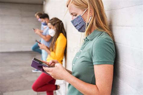 Jóvenes Con Máscaras De Seguridad Facial Usando Teléfonos Móviles Mientras Mantienen Distancia