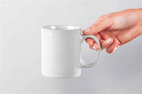 Free Hand Holding Classic Mug Mockup PSD