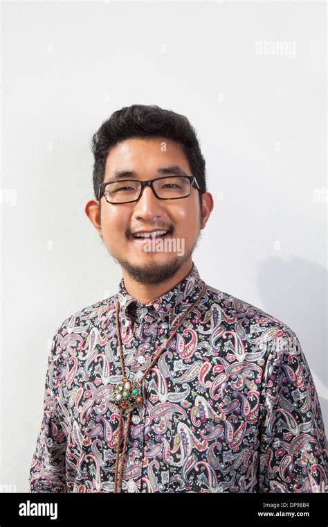 Portrait Of Happy Young Man Wearing Eyeglasses Standing Against White