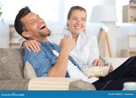 Couple Laughing And Eating Popcorn While Watching Movie Stock Image