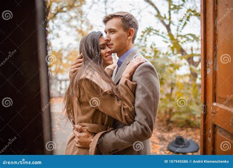 A Loving Couple Hugging Standing At The Door Outside In An Autumn Park