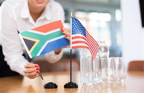 Female Hands Placing Flags Of South Africa And United States On