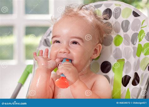 Funny Smiling Ragged Baby Holding Spoon In Mouth Stock Photo Image Of