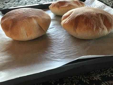 Three Loaves Of Bread Sitting On Top Of A Baking Sheet