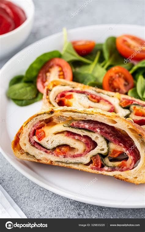 Italian Food Pizza Roll Stromboli With Cheese Salami Spinach And Red Pepper A Light Background