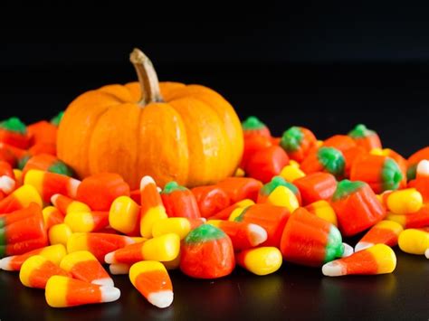 Premium Photo | Halloween candy corn and pumpkin candies on black background.