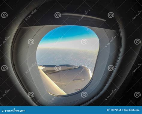 Mirada Hacia Fuera De La Ventana Del Aeroplano Y El Volar Sobre Las