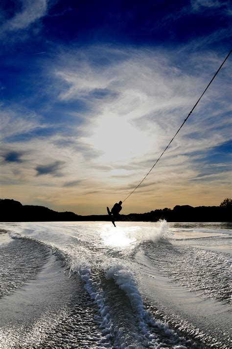 the wake boarder is being pulled through the water by his skis as the ...