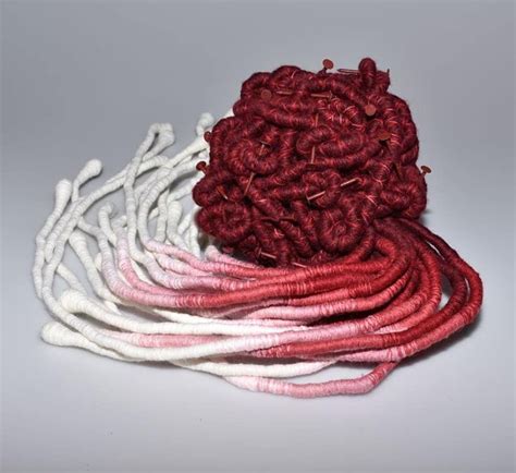 Red And White Yarns Are Stacked On Top Of Each Other