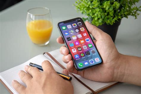 Man Hand Holding IPhone X With Home Screen IOS Editorial Stock Photo