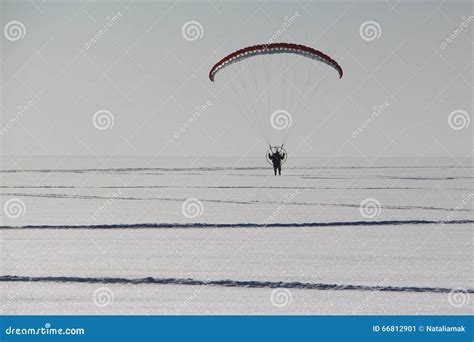 The Flying-up Person on a Motorized Paraglider Against a Snow Stock ...