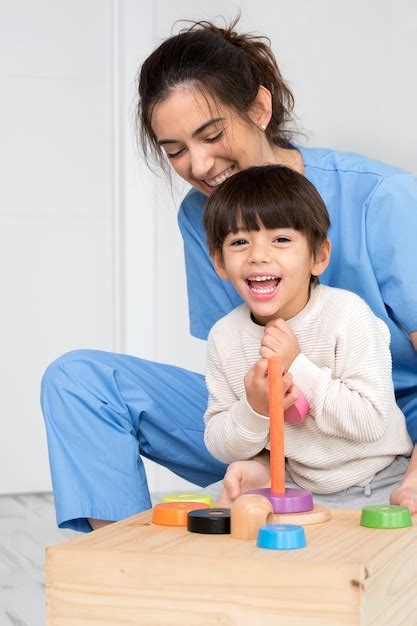 Premium Photo | Physical therapist playing with a boy who has cerebral ...