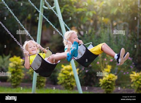 Child swinging on playground on sunny summer day in a park. Kids swing ...