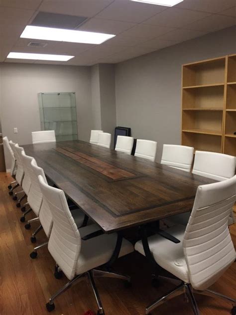 An Empty Conference Room With White Chairs And A Large Wooden Table In