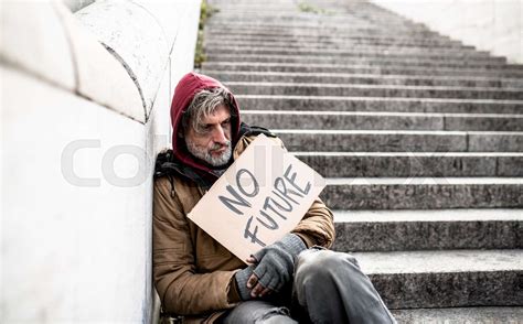 Homeless Beggar Man Sitting Outdoors In City Holding No Future