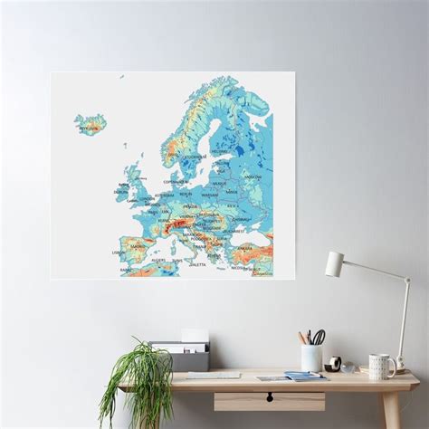 a map of europe on a white wall above a desk with a potted plant