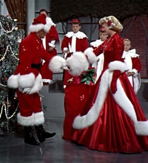 a woman in a red dress dancing with other people behind her wearing ...