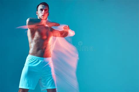 Athletic Guy With Naked Torso Raised Arms Performing Dance On Blue