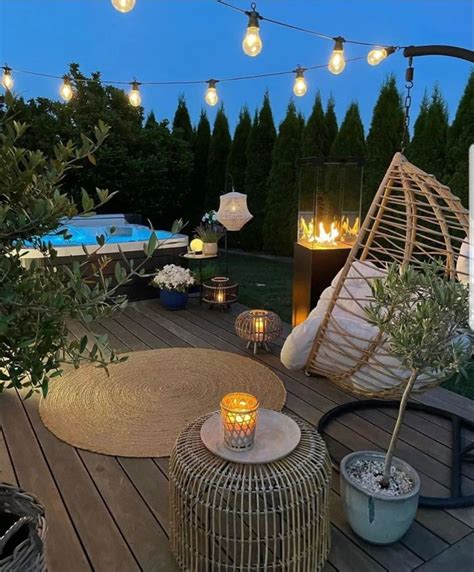 An Outdoor Deck With Lights And Wicker Furniture