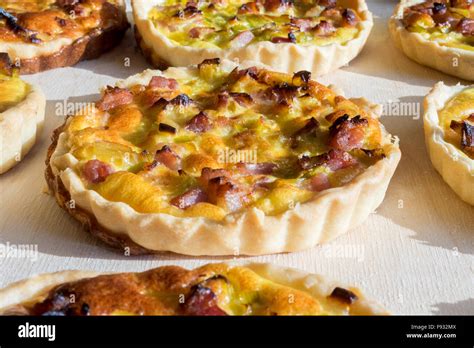 Assortment Of Quiche Lorraine Tartlets On Wooden Board Hand Made With