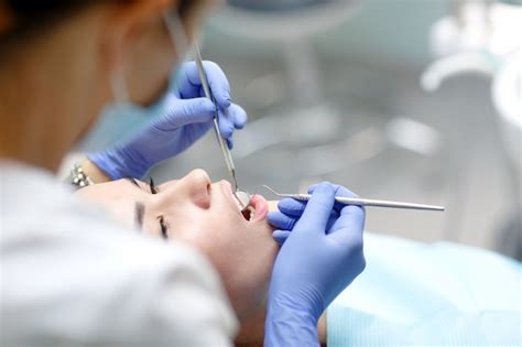 Dentista Feminina Verificando Os Dentes Do Paciente Foto Premium