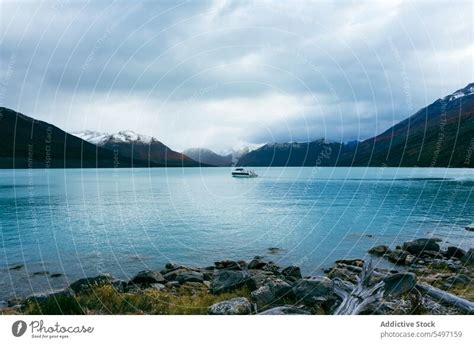 Boat Floating On Calm Lake By Icy Mountain Ridge A Royalty Free Stock