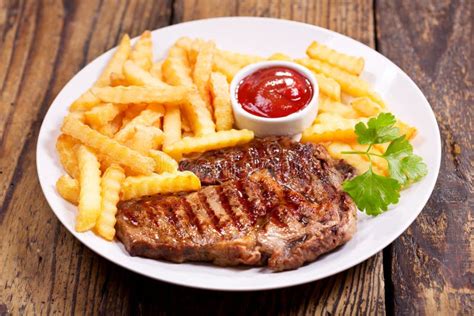 Placa De La Carne Asada A La Parrilla Con Las Patatas Fritas Foto De