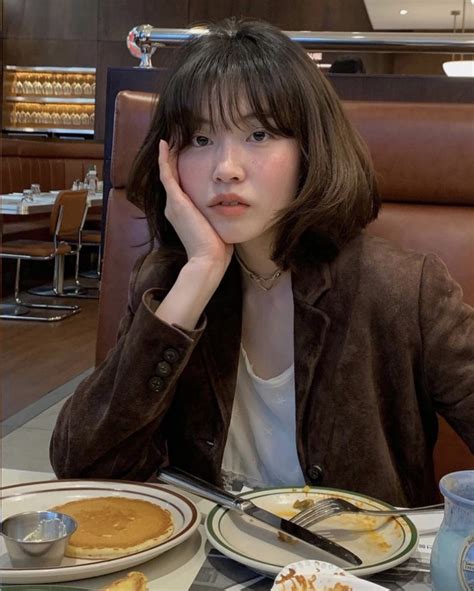 A Woman Sitting At A Table With Plates Of Food