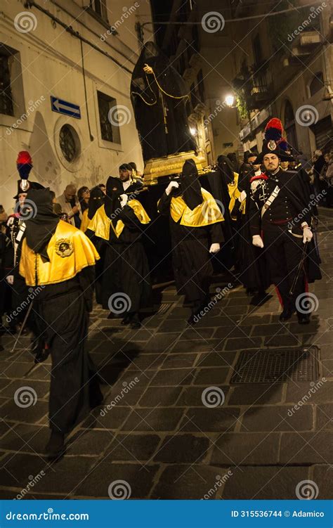 Hooded Faithful Carry The Statue Of The Madonna In Procession Flanked