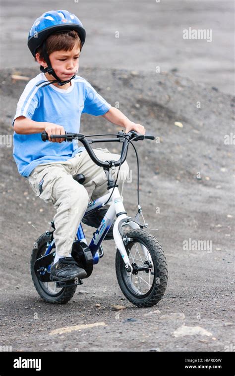 Caucasian child, boy, 8-9 years, peddling child's bike on dirt trail ...