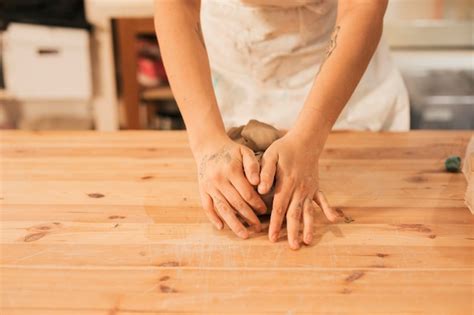 Free Photo Close Up Of Female Potters Hand Kneading The Clay On