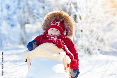 Sled and snow fun for kids. Baby sledding in winter park. Stock Photo ...