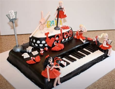 A Birthday Cake Decorated With Musical Instruments And Women In Red