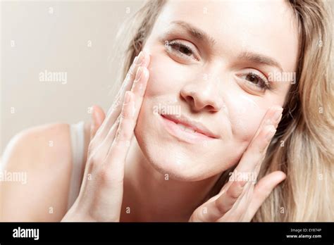 Young Woman Applying Lotion On Face Close Up Stock Photo Alamy