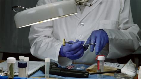 Scientific Police Examining A Bullet Cap In Ballistic Laboratory Stock