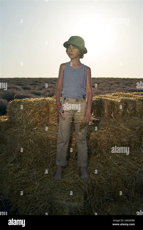 Portrait Of A Barefoot Boy In A Sleeveless Shirt And Trousers With