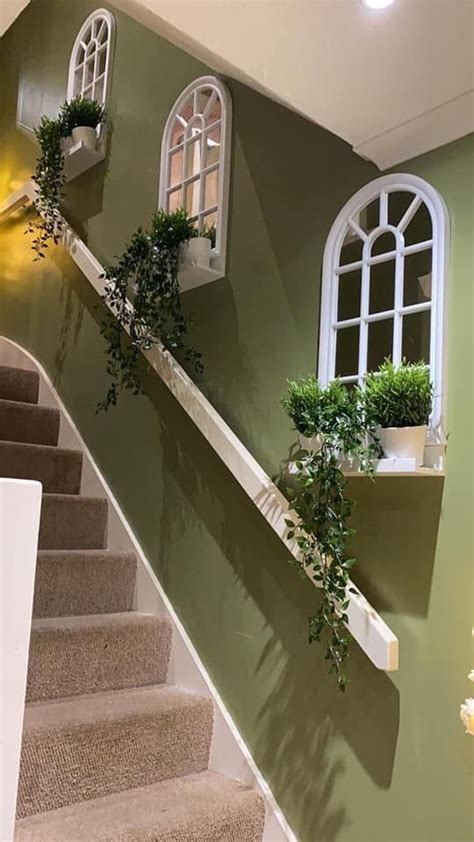 The Stairs Are Painted Green With White Windows And Potted Plants On