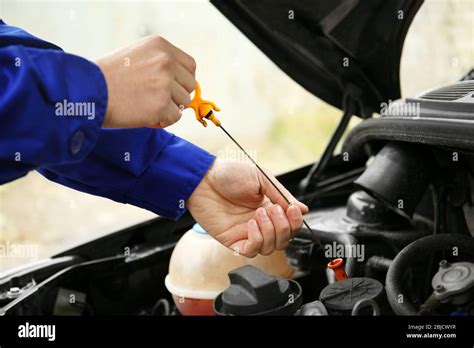 Mechanic repairing car with open hood Stock Photo - Alamy