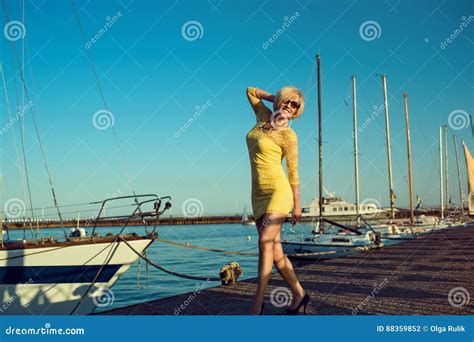 Portrait Of Gorgeous Middle Aged Blond Smiling Woman Wearing Yellow