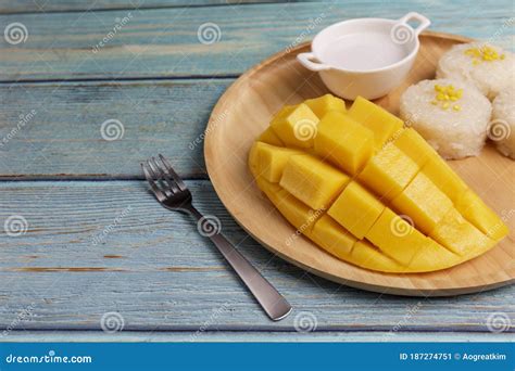 Yellow Half Mango With Small Fork Mango Fruit Cubes On The Blue Wooden