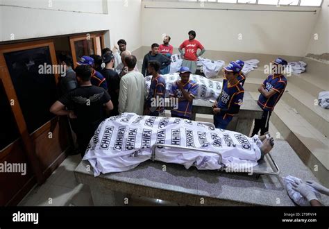 Health Workers Stand Near To The Bodies In A Morgue After Fire In A