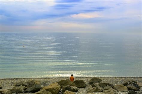 Premium Photo A Beach On The Black Sea Coast A Man Among Boulders